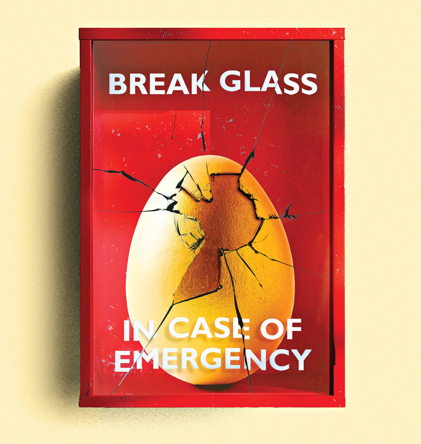 Photo illustration of a golden egg in a red emergency case, the glass has been shattered to open it