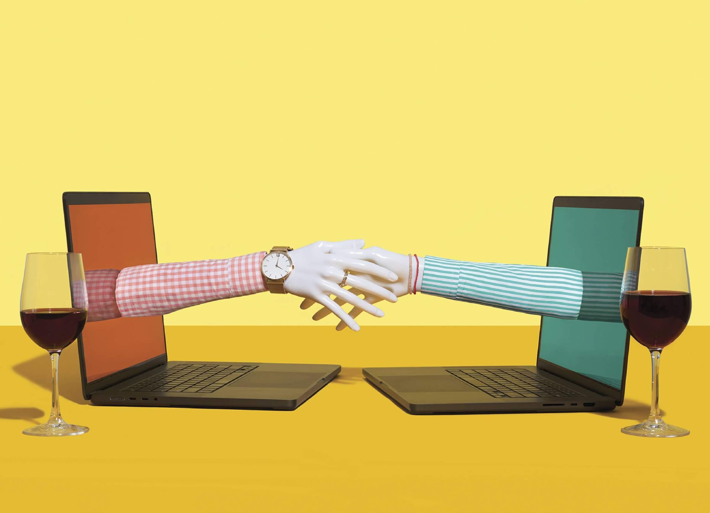 Photocollage of two laptop screens facing each other with wine glasses next to them. The laptop screens have hands reaching out from them that are shaking.
