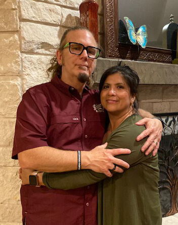 Image of Joseph and Reyna Tharp in front of a fireplace