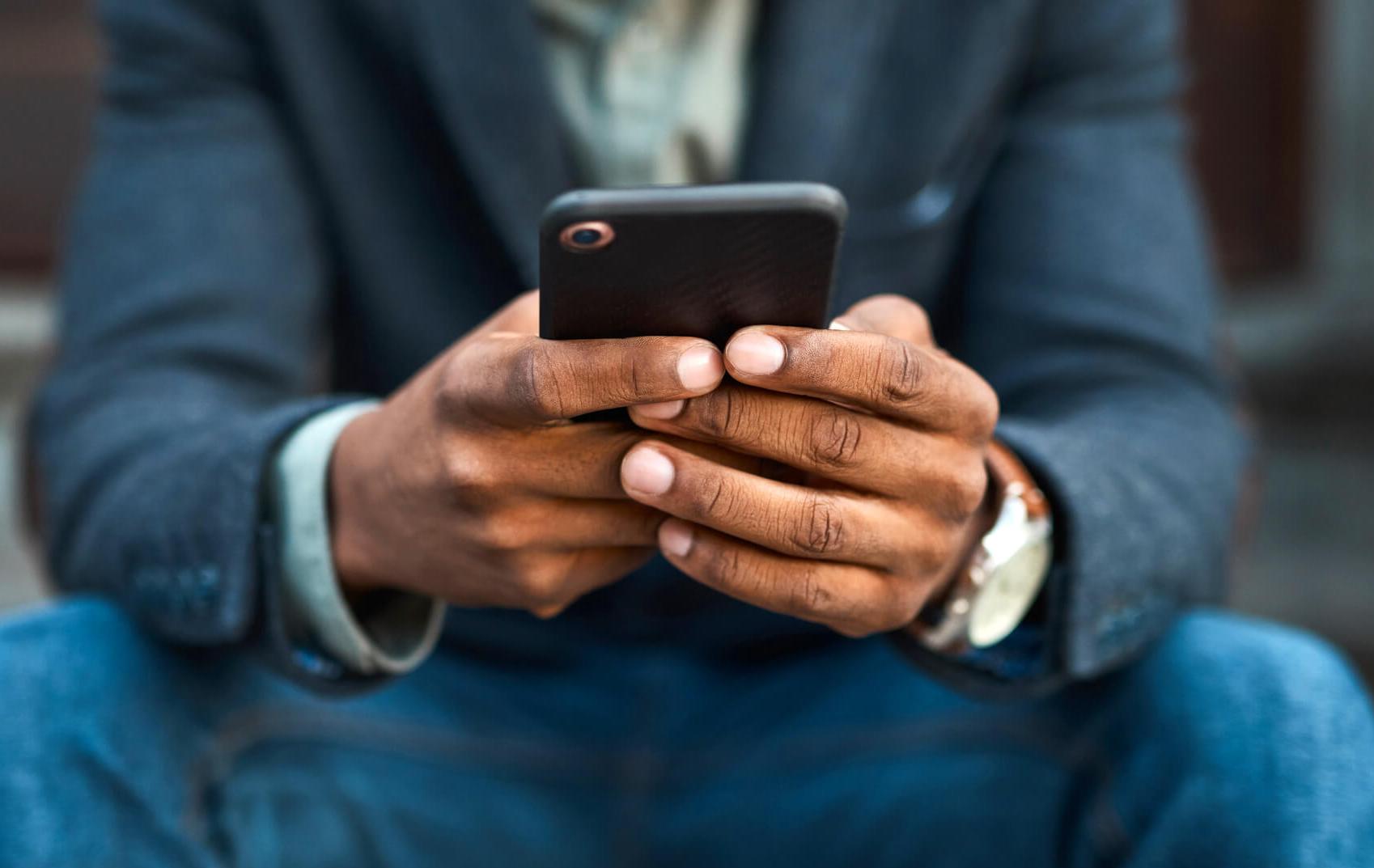 Close-up photo of a man's hands holding a smartphone