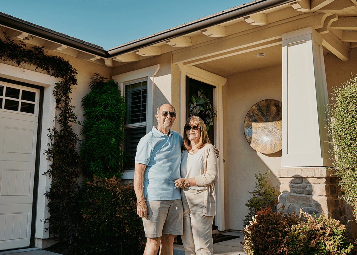 Photo of Steven and Denise Rosen in front of their home