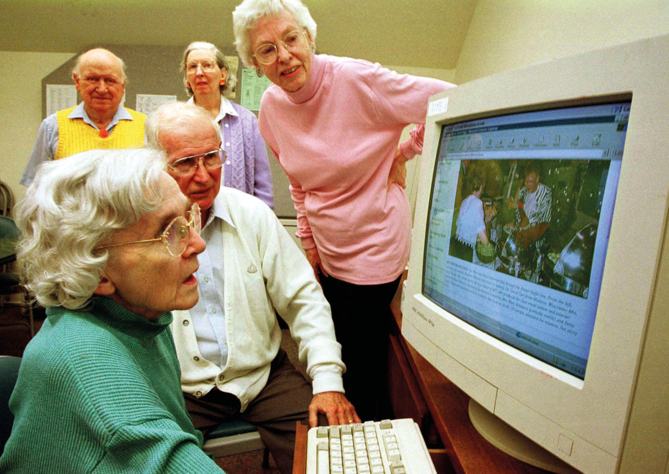 Photo of people looking at one of AARP's first online portals