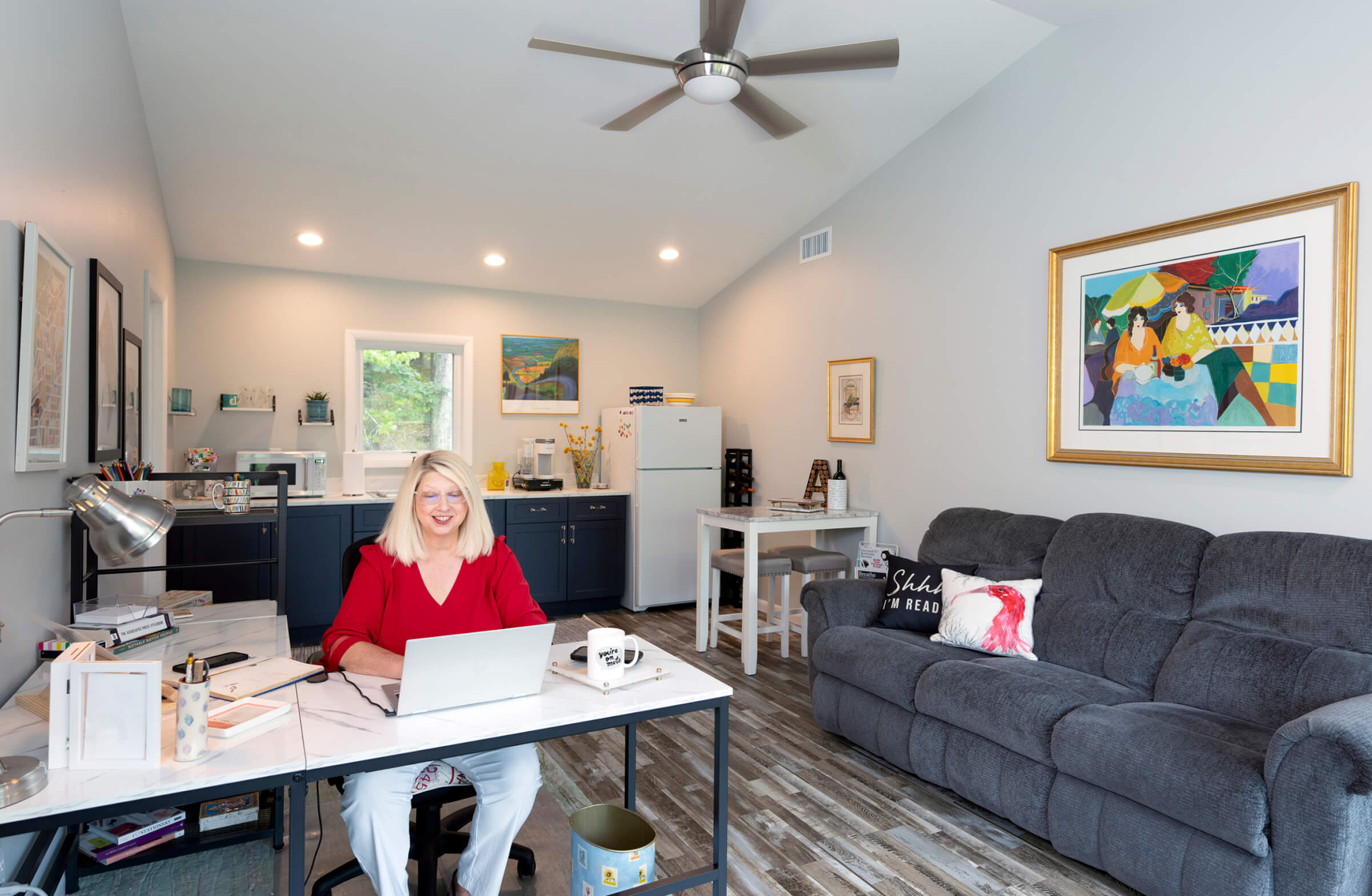 Photo of Ann Davison sitting at a desk in the living quarters above her garage