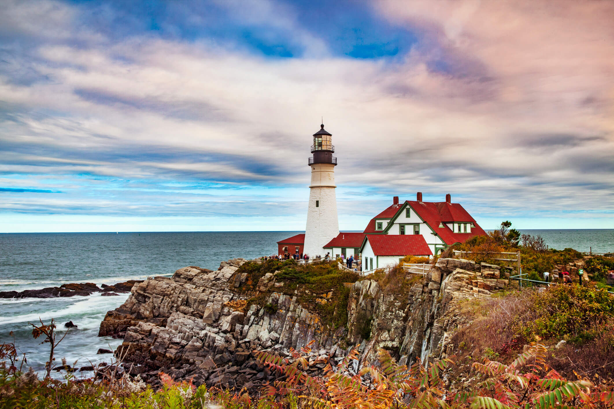 Photo of a lighthouse on a cliff overlooking the ocean