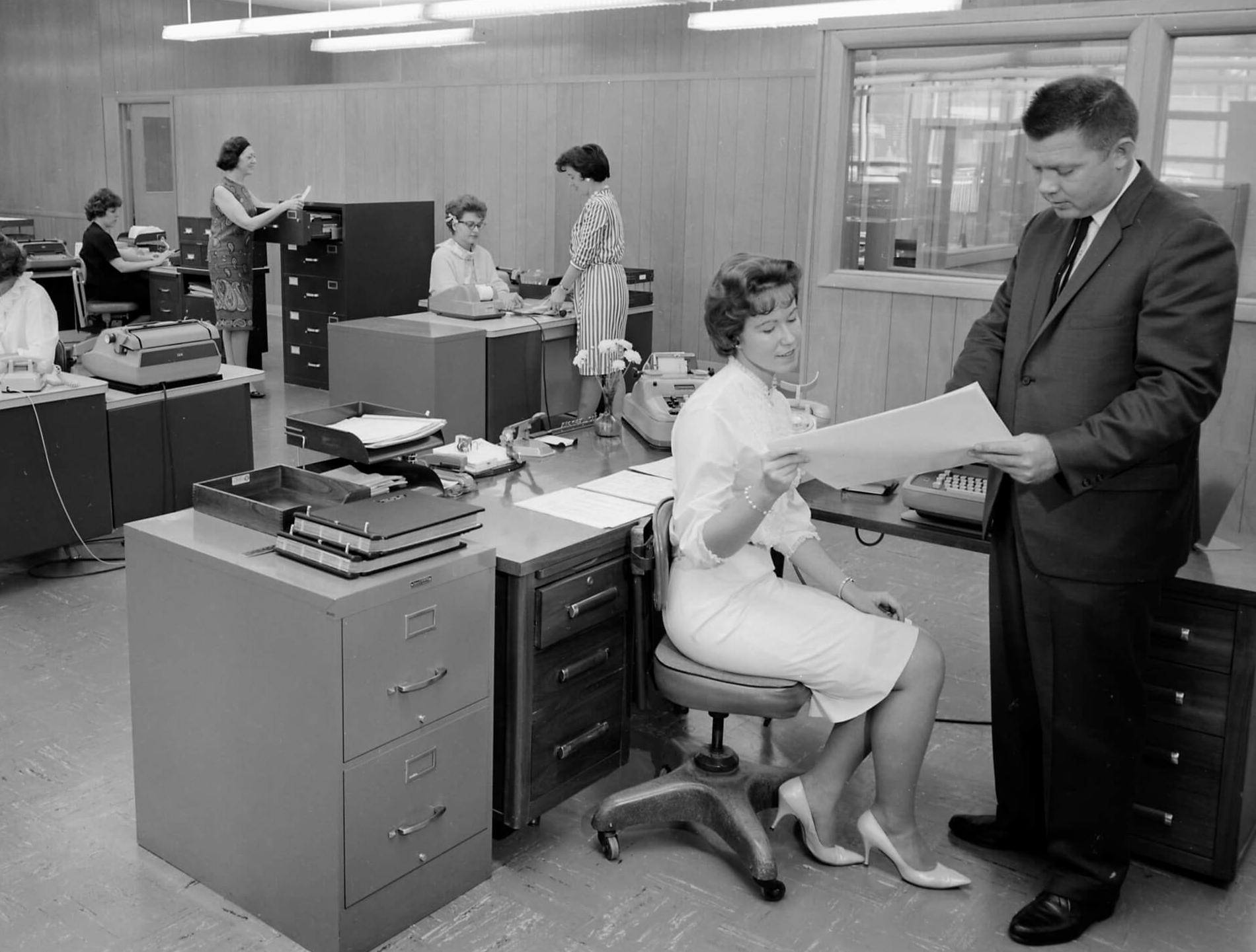 Vintage black and white photo of people working in an office