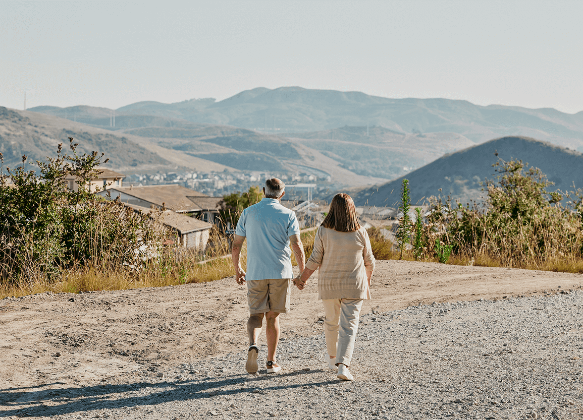 Photo of Steven and Denise Rosen walking towards some mountains in the distance