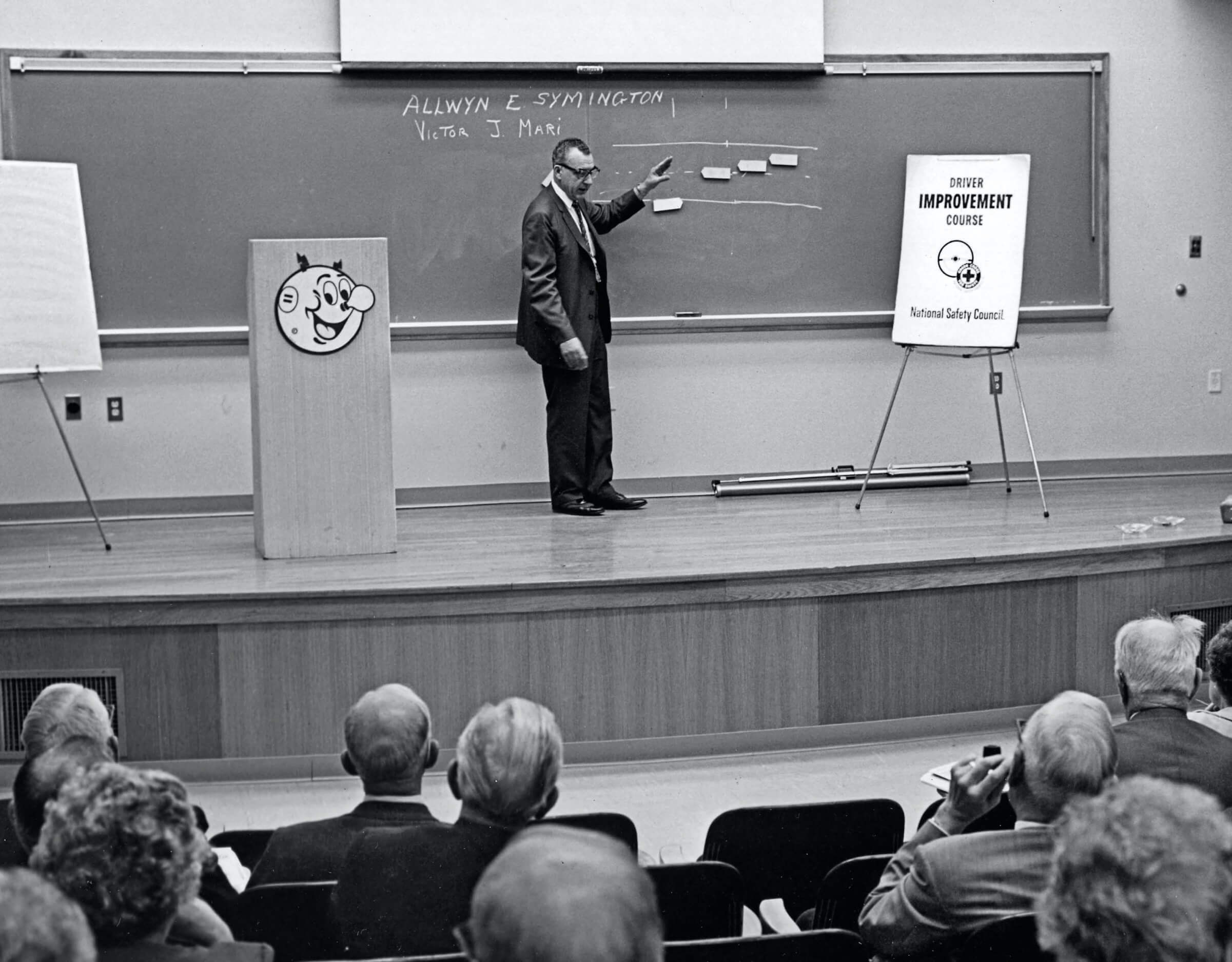 Vintage black and white photo of people attending a driver improvement course