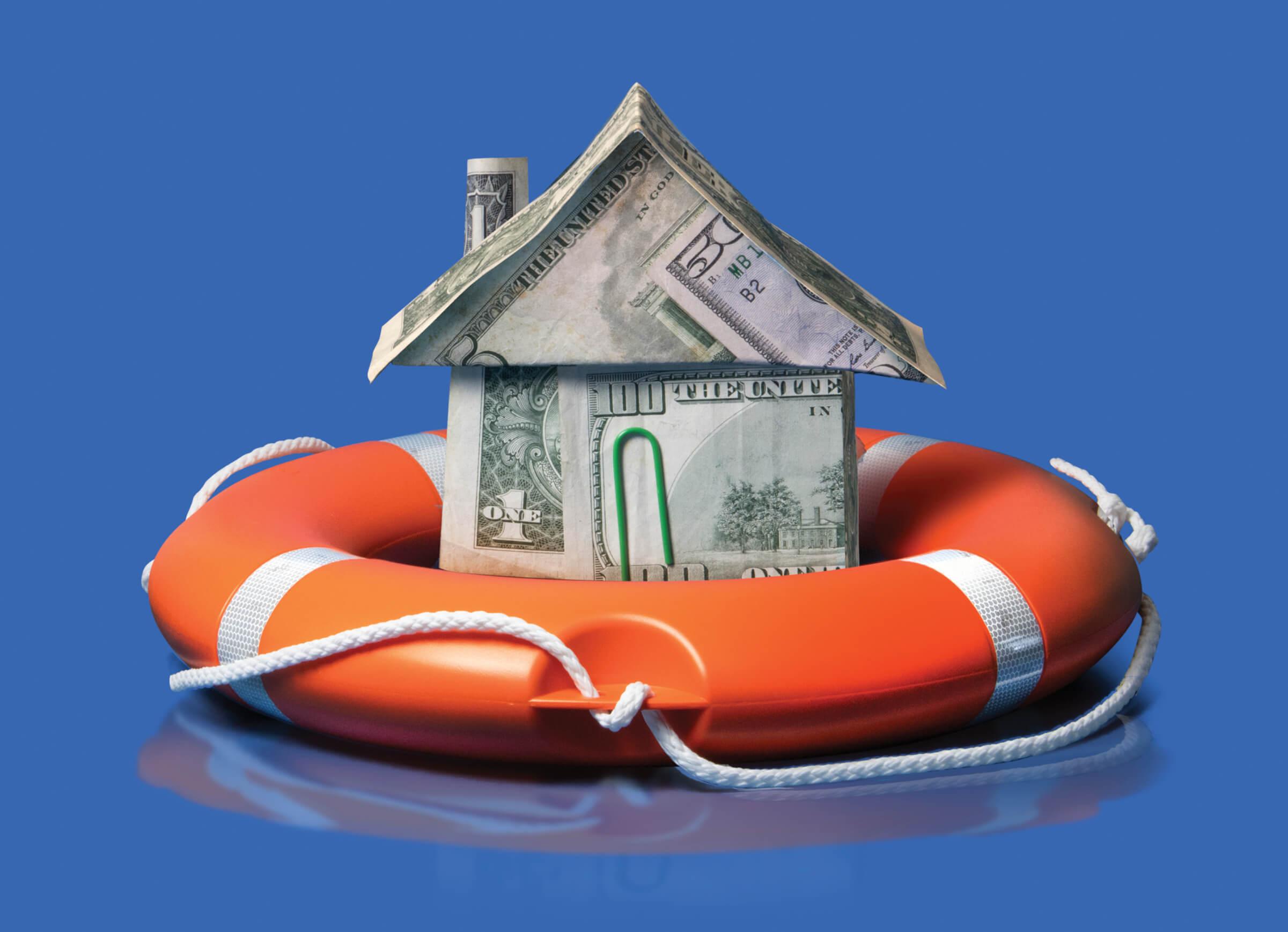 Photo of a house made of dollar bills resting in a life ring