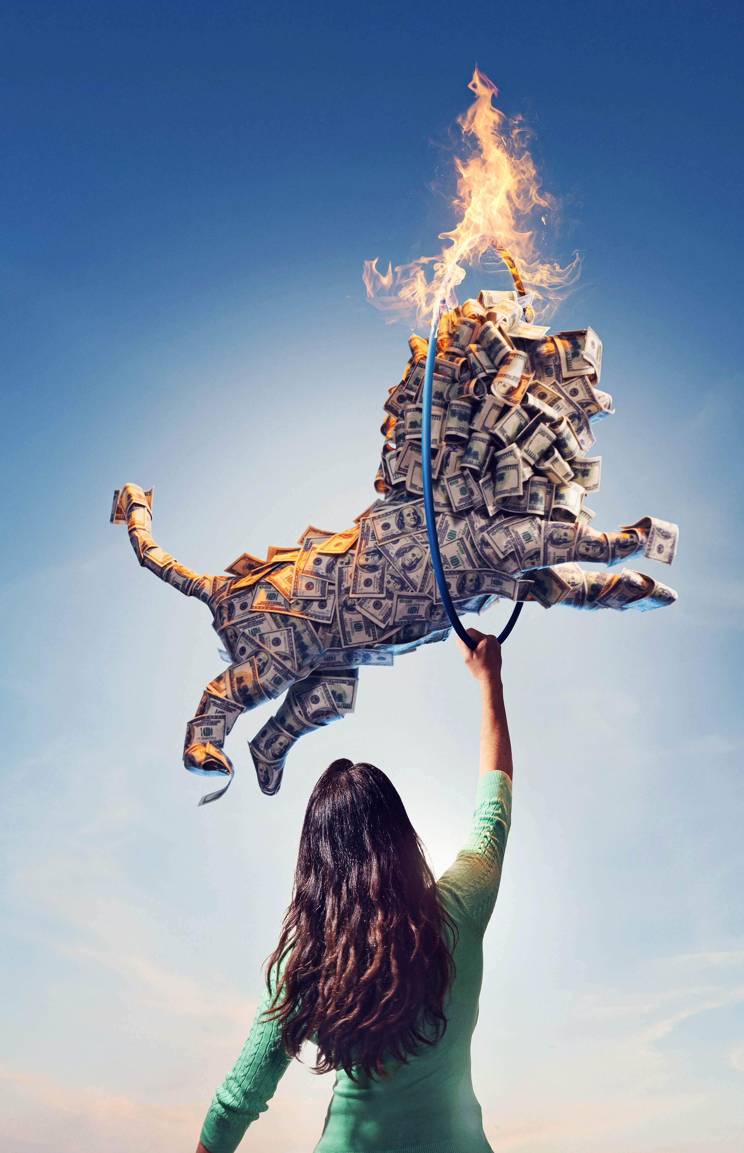 Image of a woman holding up a hula hoop that’s on fire that a lion made of dollar bills is jumping through