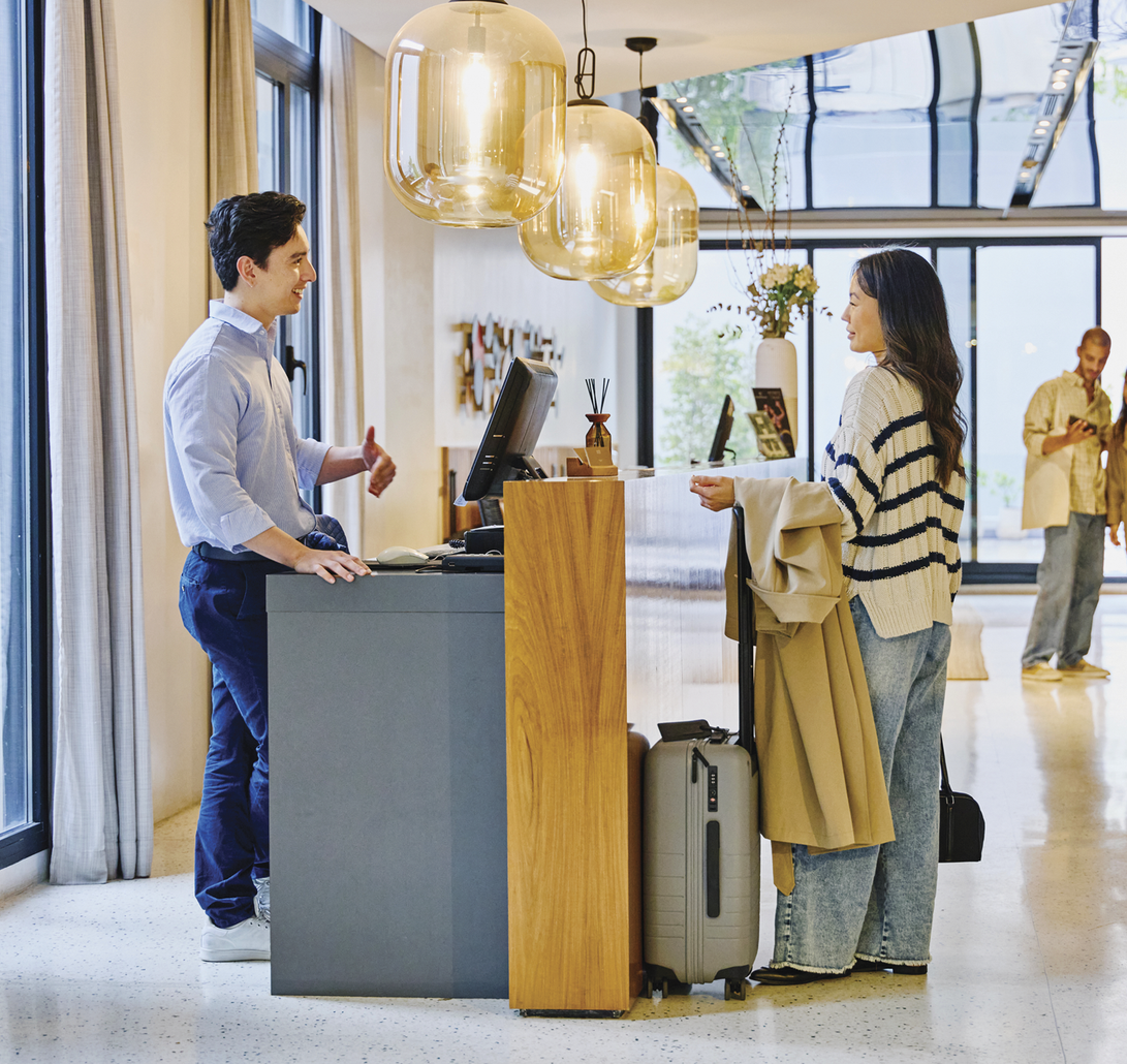 Image of a woman standing a hotel reception.&nbsp;