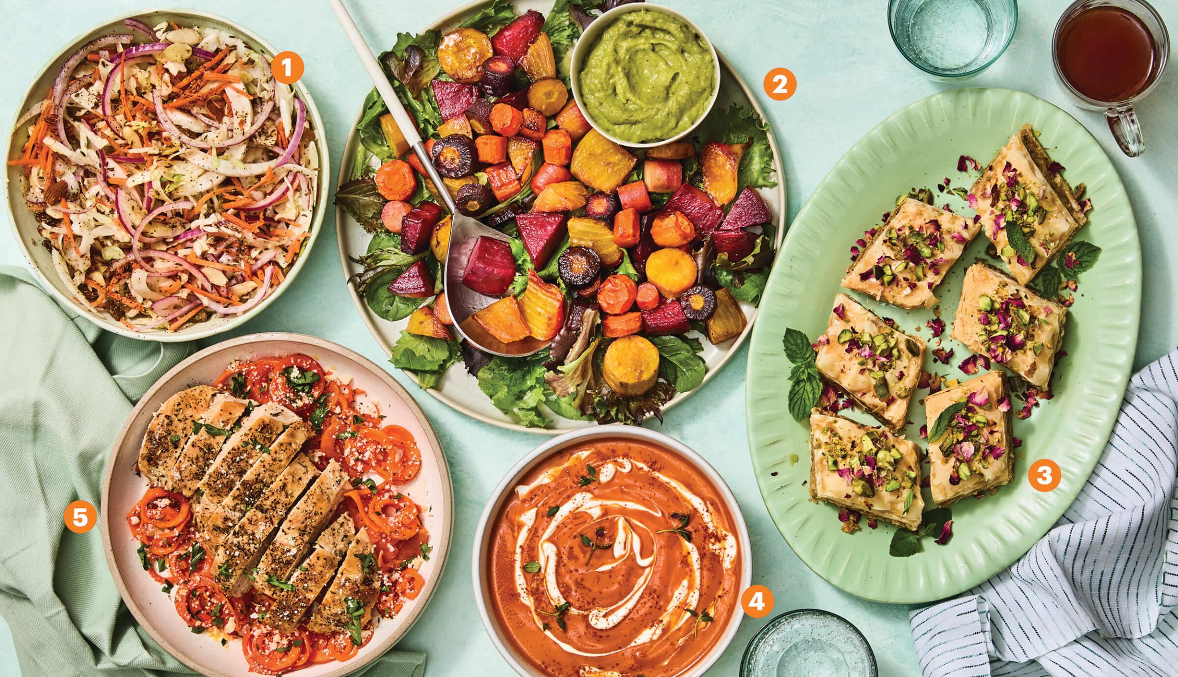 Top view of a spread of food featuring 5 dishes made of carrots