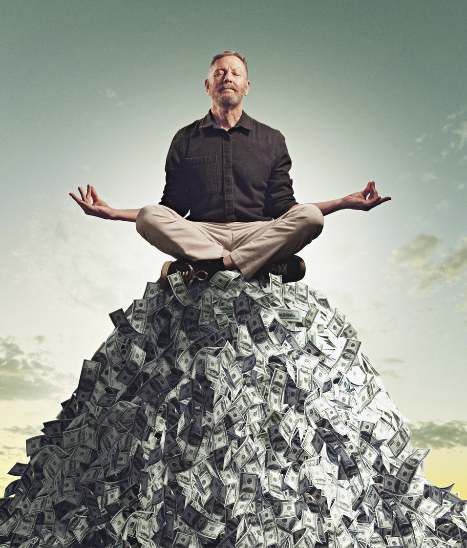 A person meditating on a pile of dollar bills&nbsp;
