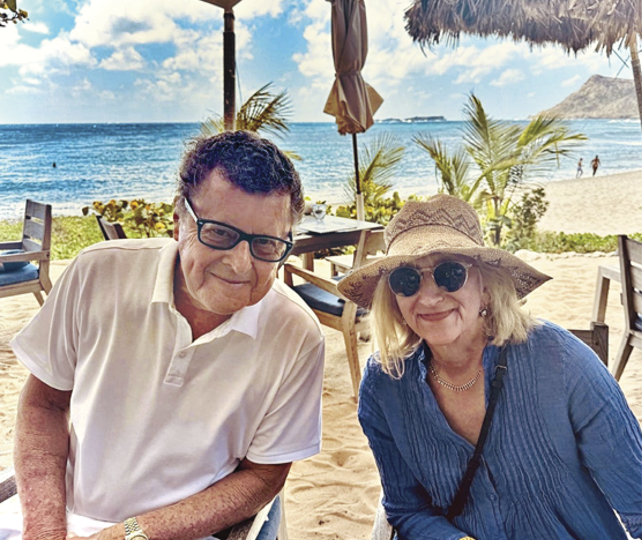 Photograph of Andres Newman with her husband sitting at a beach&nbsp;
