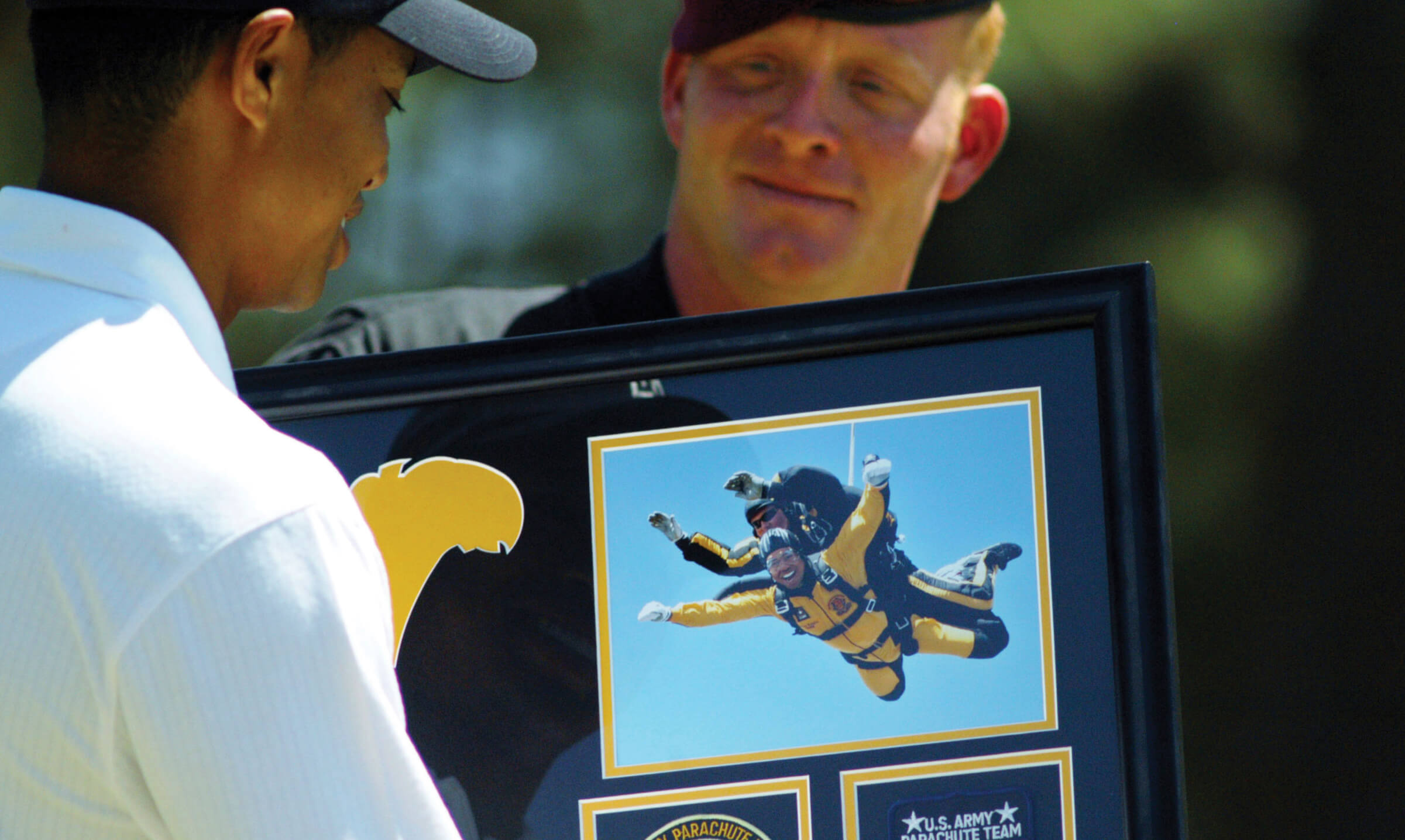 Photo of Tiger Woods accepting a photo of himself parachuting