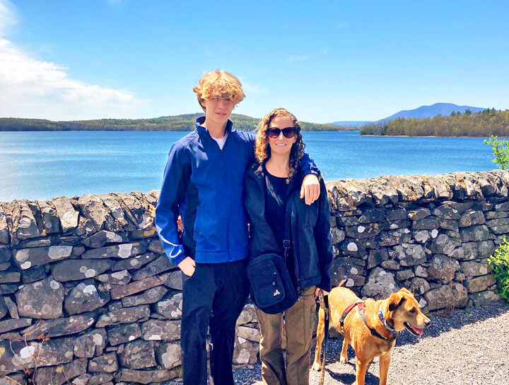 Photo of Aileen Weintraub with her son and their dog in front of lake