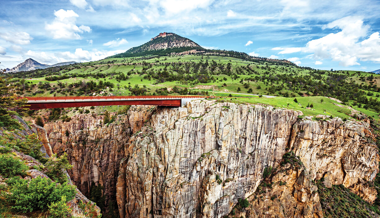 Photo of road running through mountain landscape.