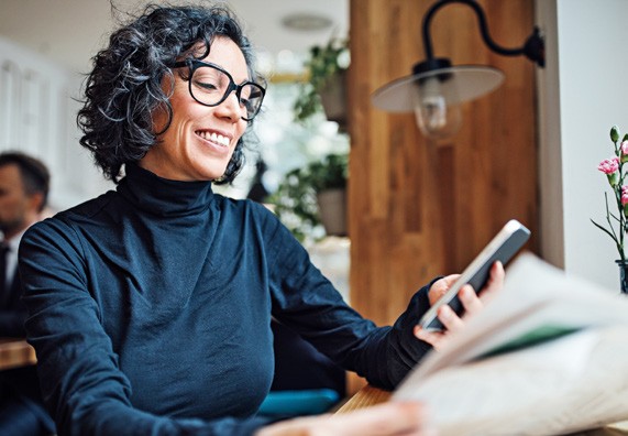 Photo of woman smiling at her cell phone