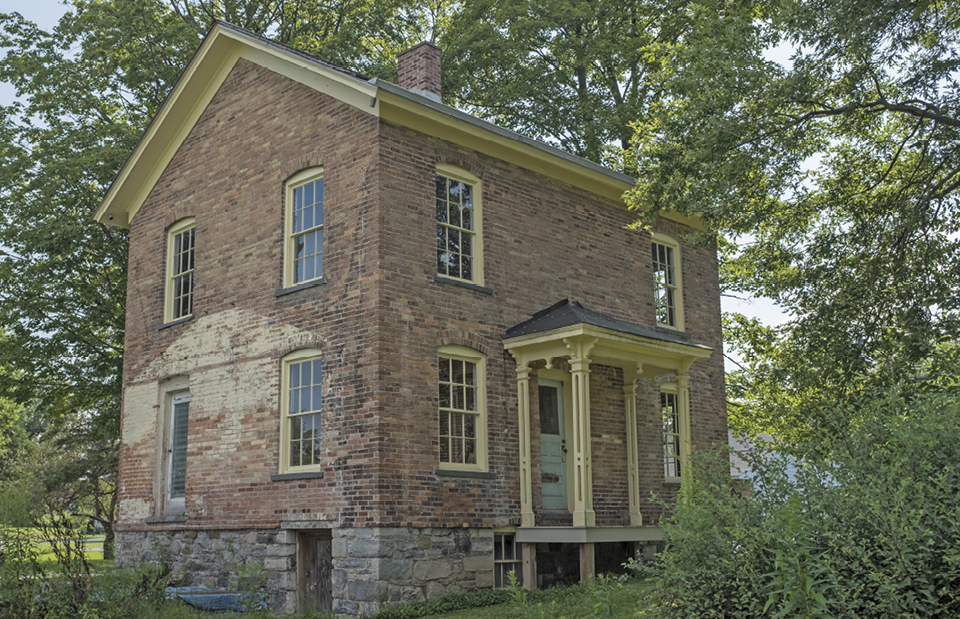 Harriet Tubman's preserved two-story brick residence stands nestled among lush green trees in Auburn, New York