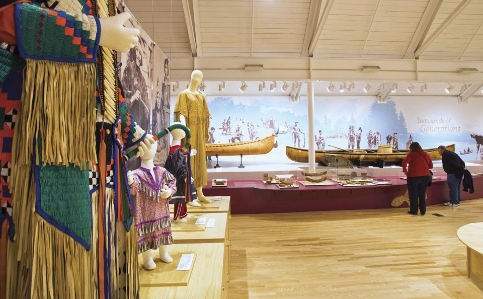 Inside of the Abbe Museum, showcasing various colorful garments 