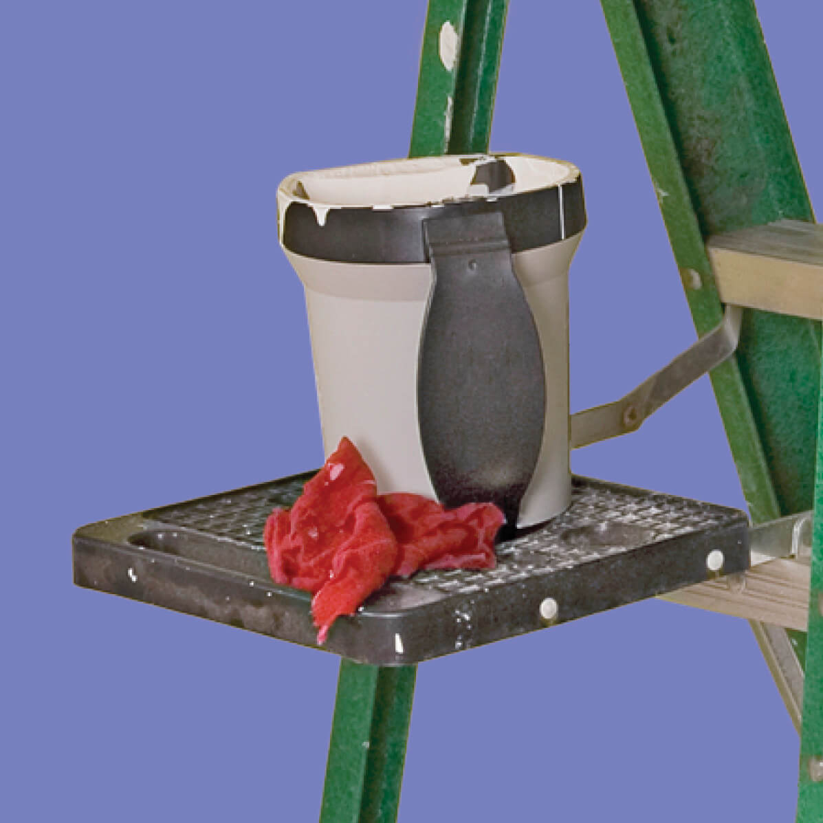 Photograph of a platform on the side of the ladder with a bucket and a rag cloth on it 