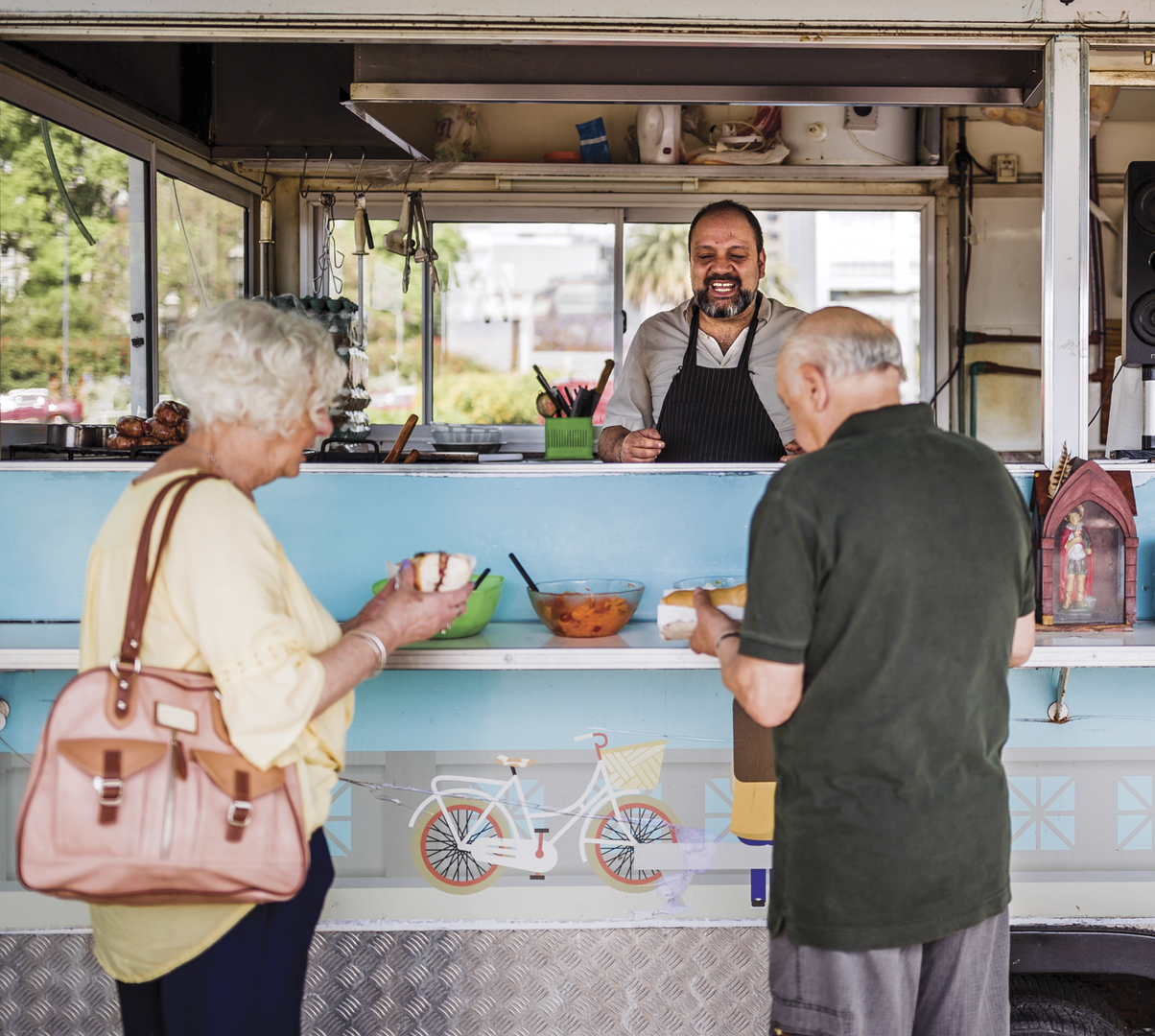 An older couple grabbing street food from a vendor 