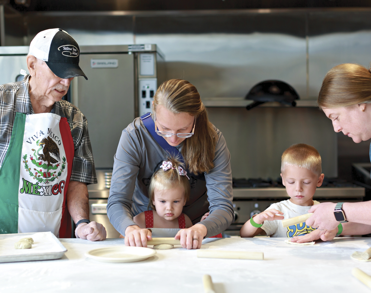 Image of parents and children in the kitchen cooking together 