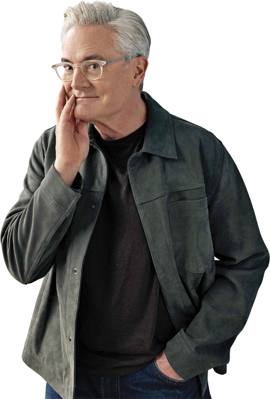Silhouette of Kyle MacLachlan. He is wearing a dark green jacket and is smiling at the camera 