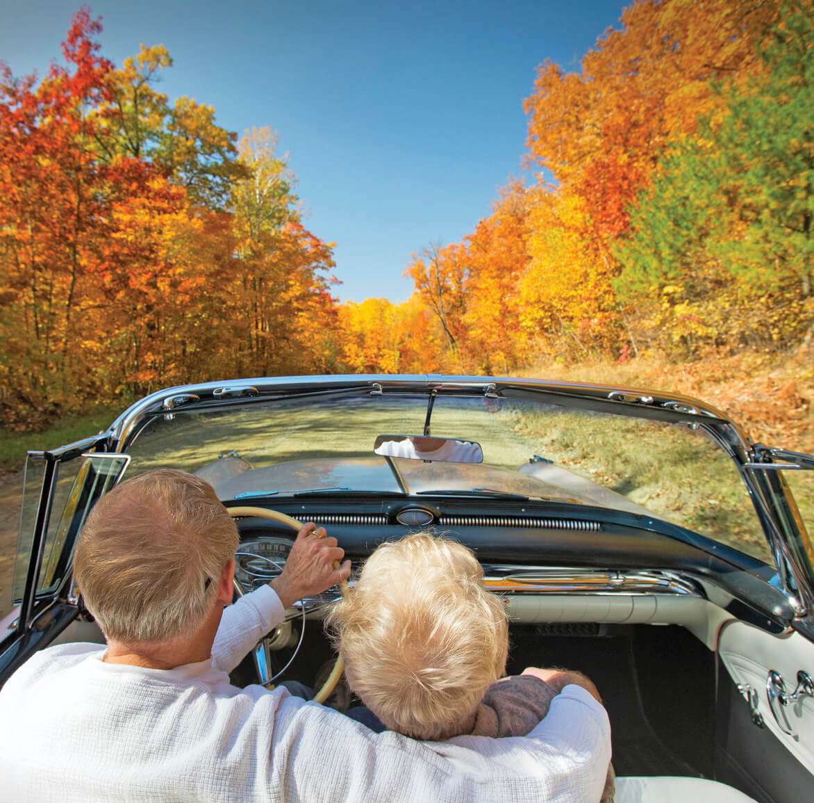 Image of a couple sitting in a car and driving down a road