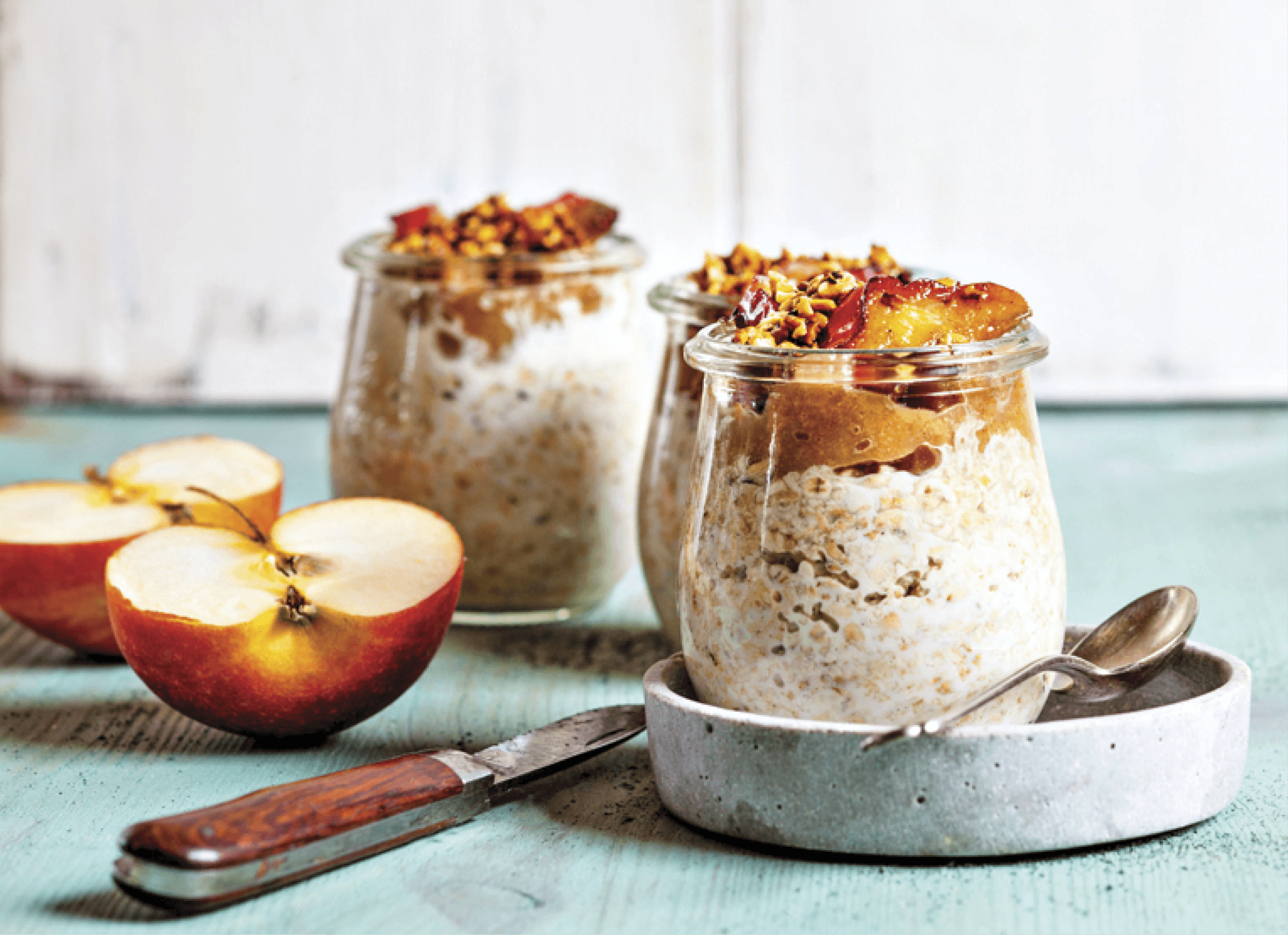 Photograph of three glass jars with overnight oats in it. Image of cranberries 