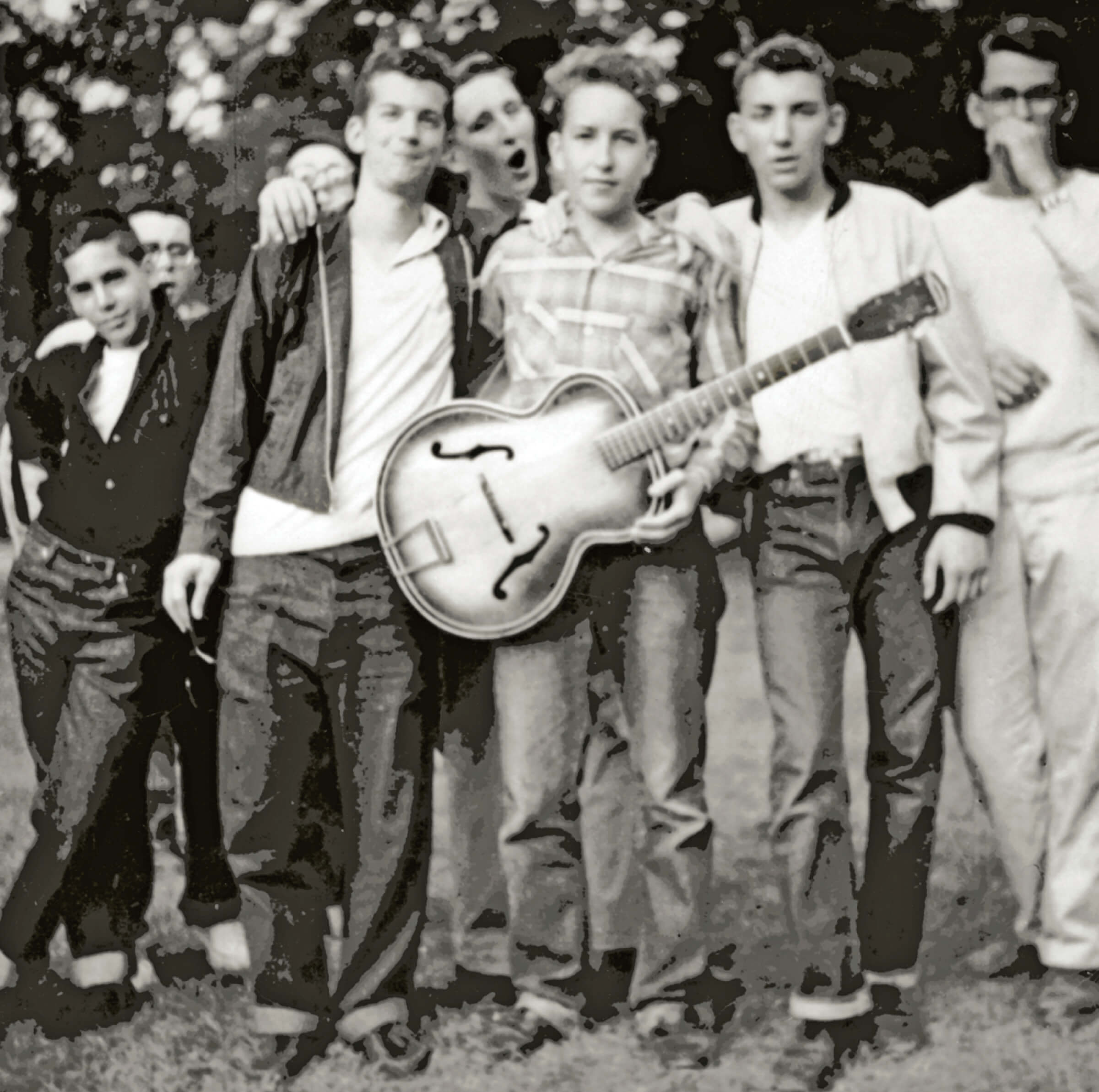 Photo of Bobby Zimmerman holding a guitar with fellow summer campers in 1957