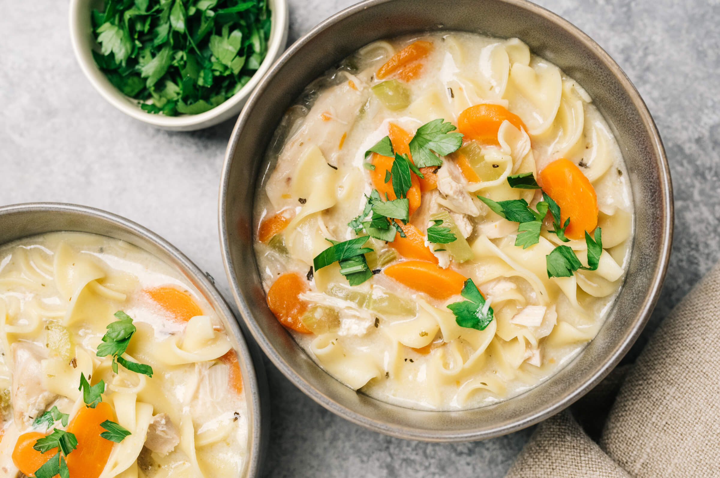 Photo of bowls of chicken soup topped with cilantro leaves