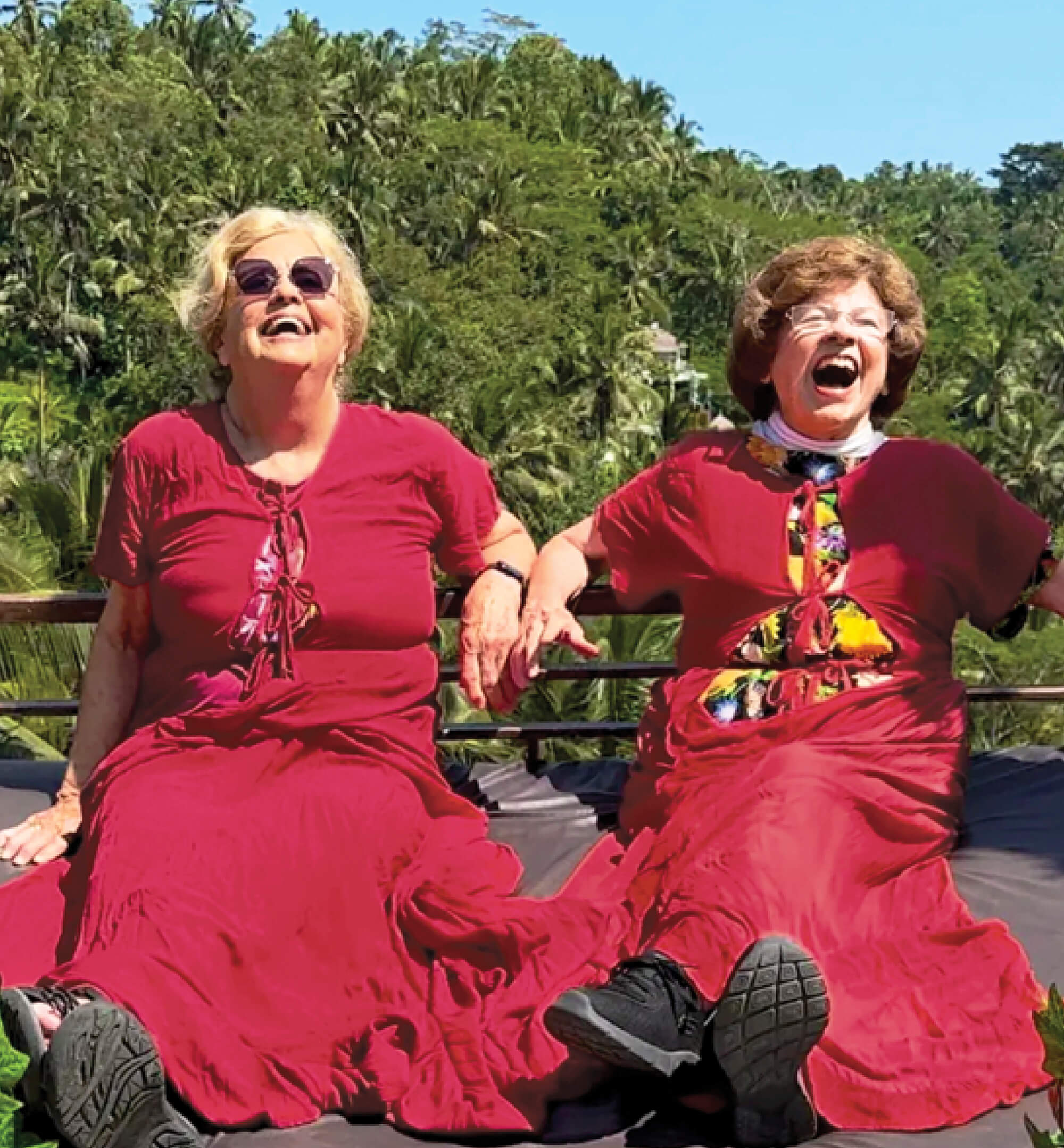 Photo of a laughing Ellie Hamby and Sandy Hazelip wearing red dresses