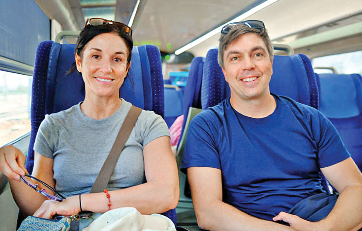 Photograph of Laura Kiniry and her husband Adam Hodge sitting on a train during their travels in India