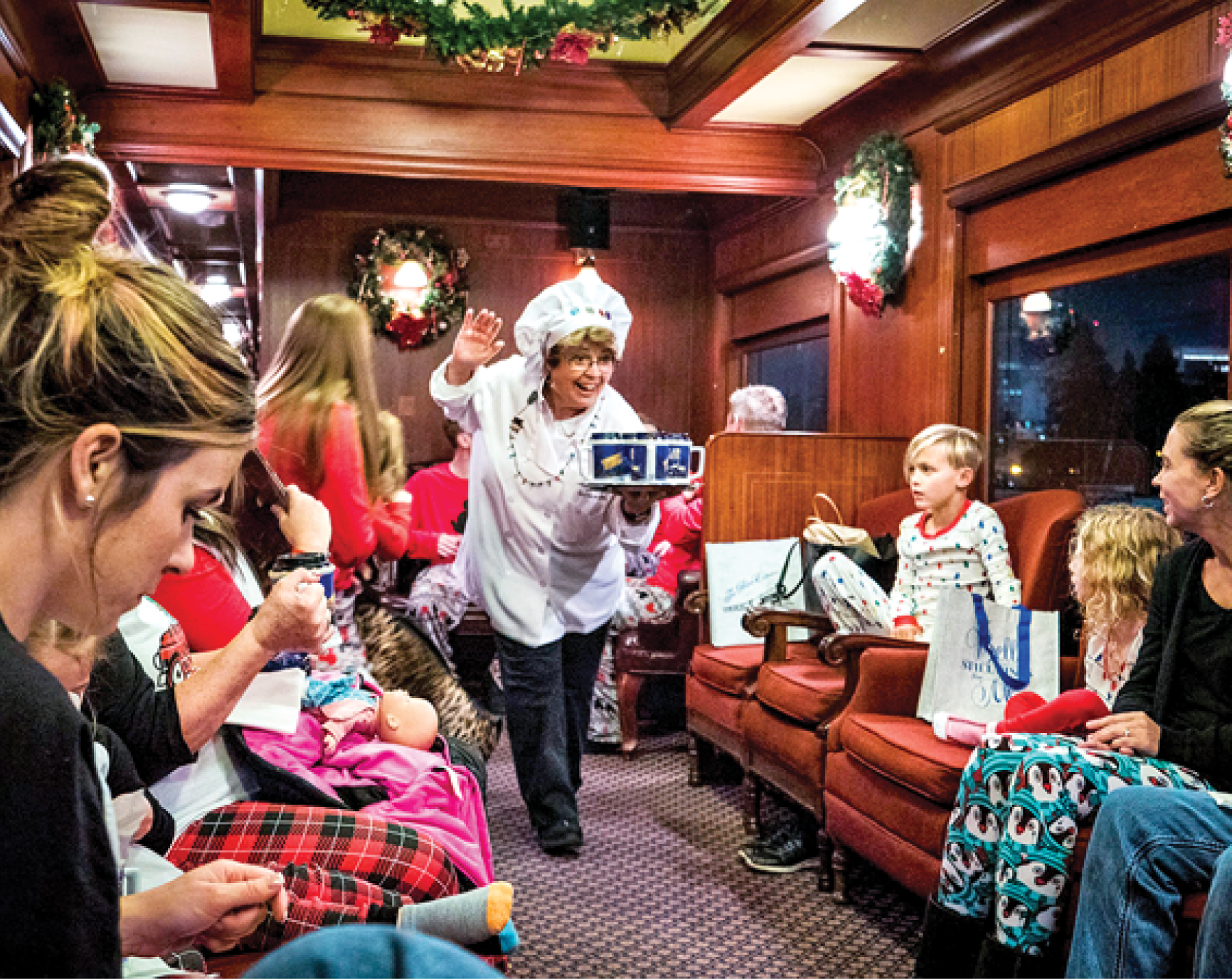 A family sitting around in pajamas on the train, having a good time