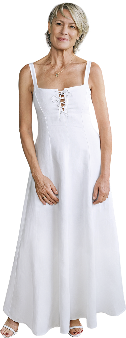 Portrait of Robin Wright wearing a long white dress and heels.