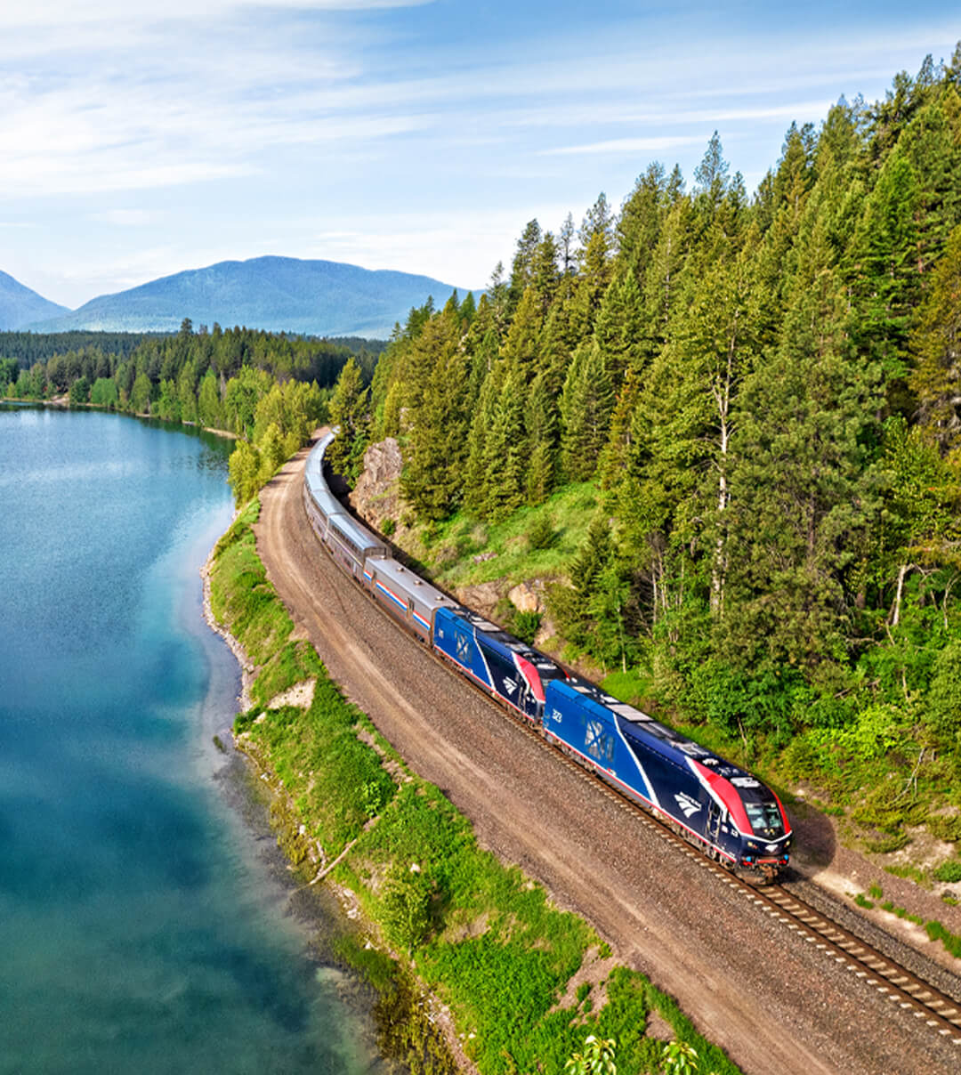 Top view photograph of Amtrak's Empire Builder on the shores of Lake Fiver near Coram, Montana.
