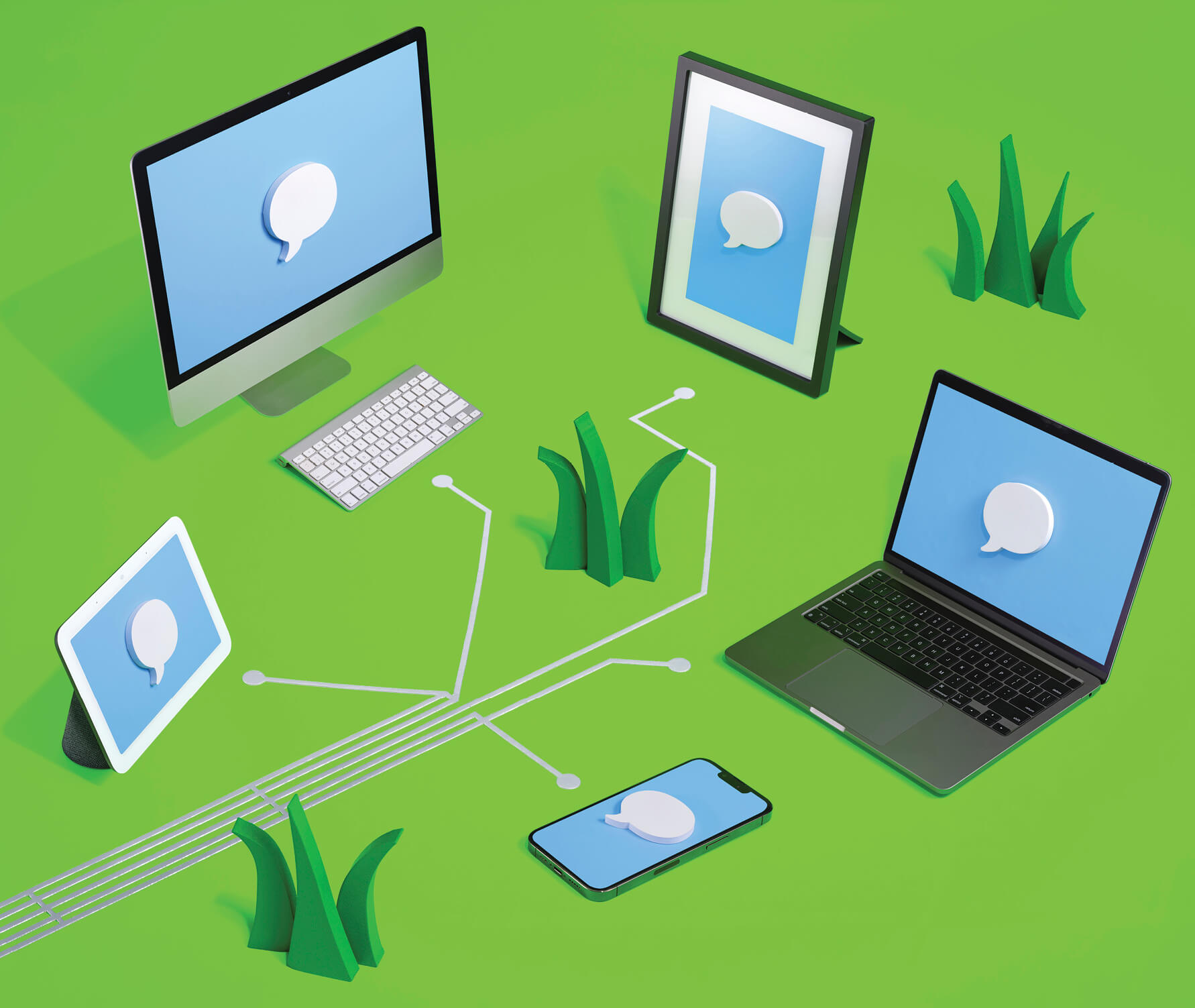 Photo of different tech devices on a green background: Desktop computer, laptop, tablet, smart phone, and smart photo frame. All screens have text bubbles on them.