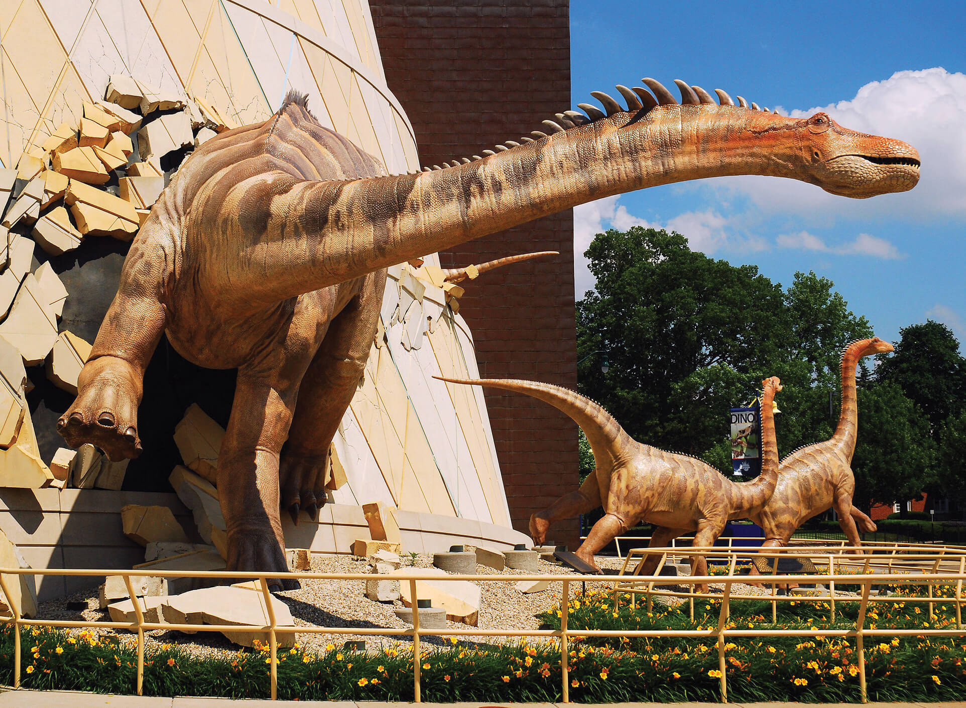 Photo of dinosaur statues coming out of Children's Museum of Indianapolis building