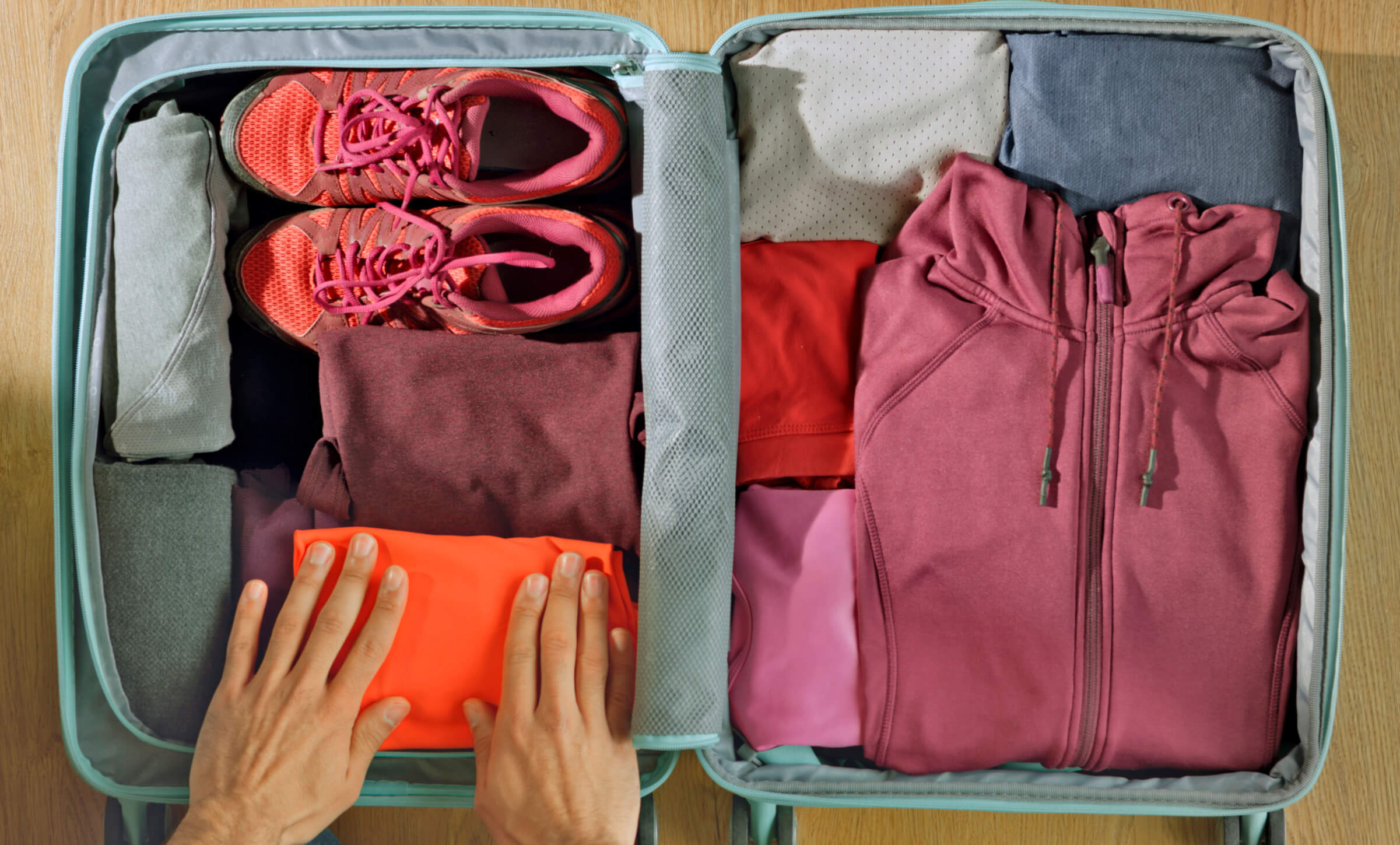 Photo of an open carry-on bag with various types of clothing