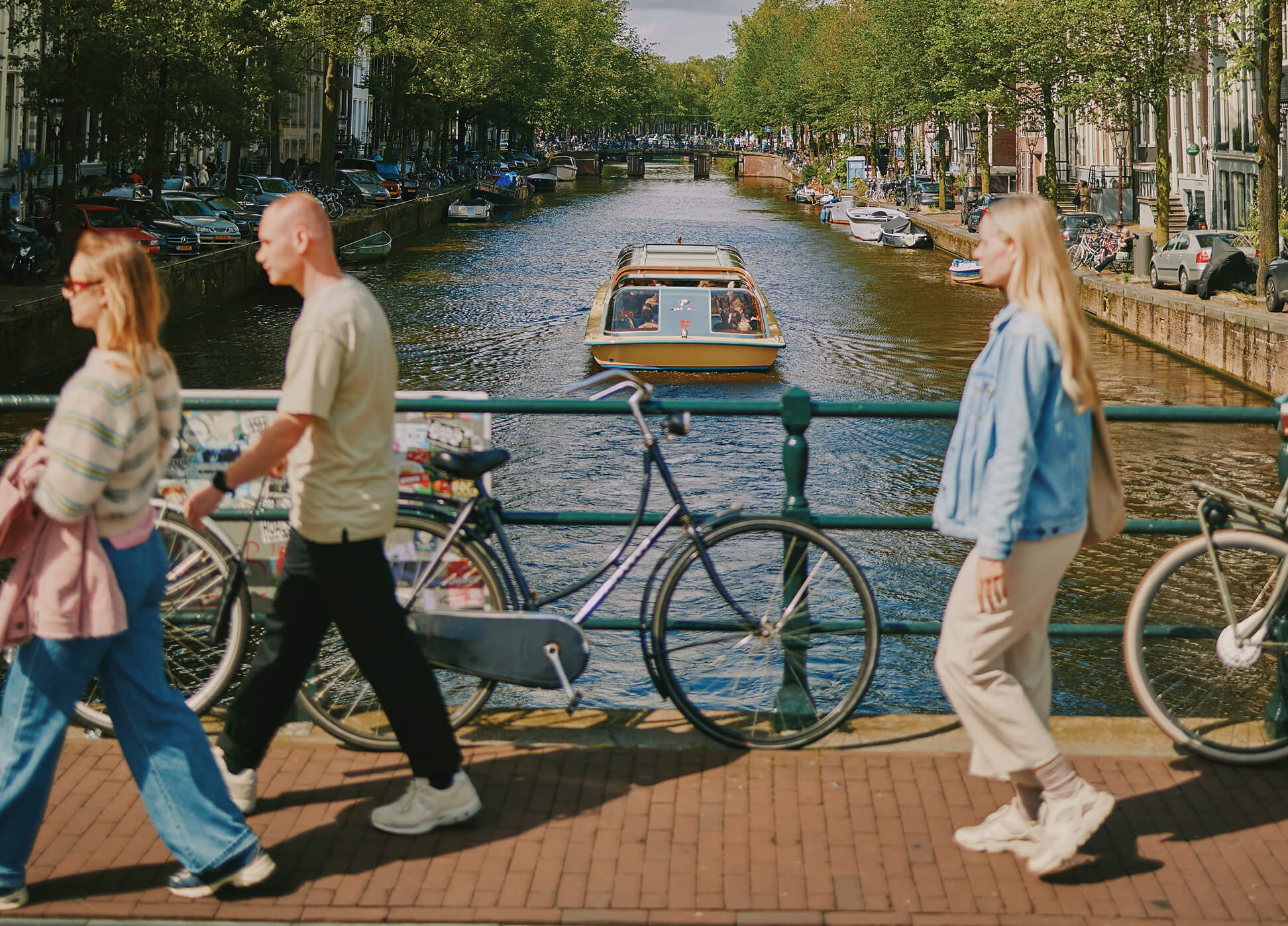 Photo of people walking along canal in Amsterdam