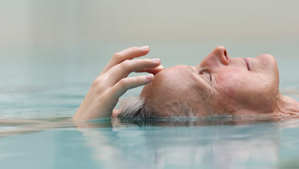 A woman meditates in a pool.