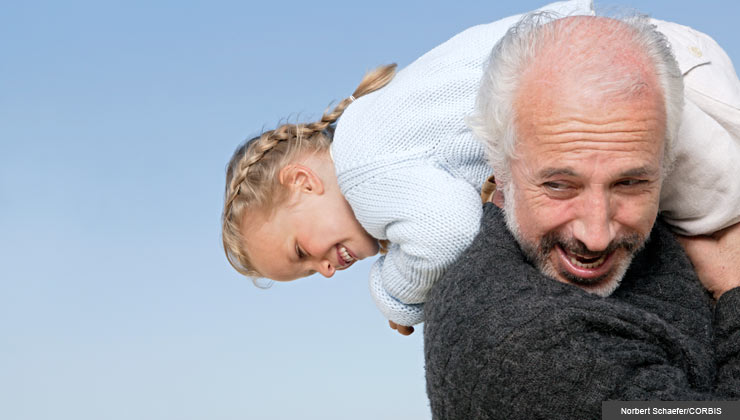 Senior man crarrying granddaughter on his shoulders