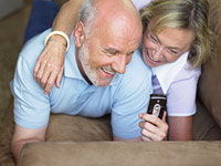 Grandparents guide how to social network with grandkids - couple on a sofa.