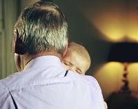 Grandfathers can often be better grandparents than they were fathers according to this essay published on AARP.org- a grandfather snuggles his baby grandchild