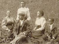 African American family posed for portrait seated on lawn, 1899