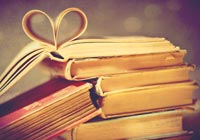 best books about romance- a stack of books with a heart folded in the pages
