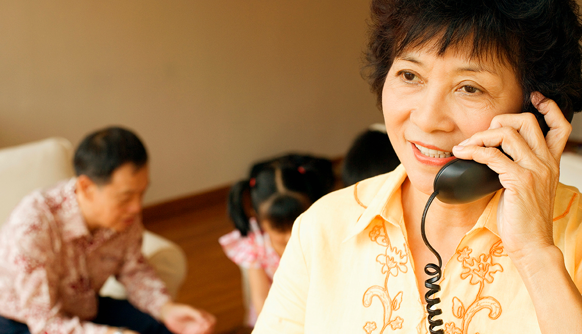 Mature Asian woman, using landline telephone, Telecommunications,  AARP Research, Technology