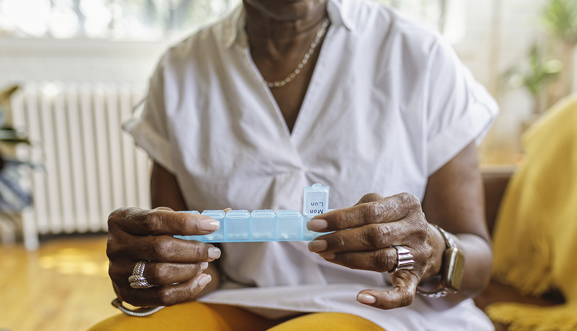 Older Black Woman Examining Medication Dispenser