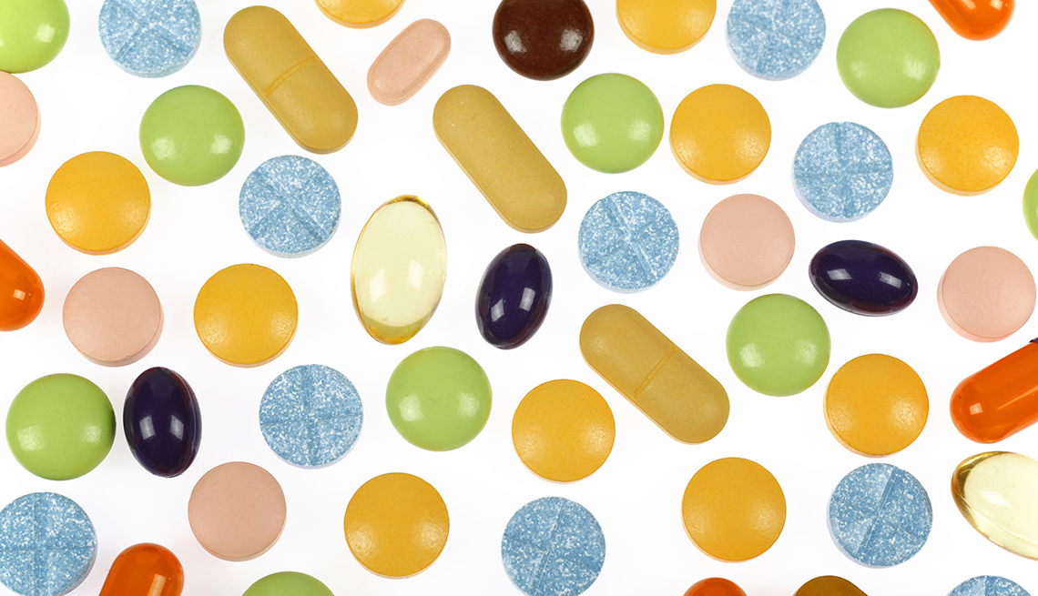 Various colorful pills and supplements on white background
