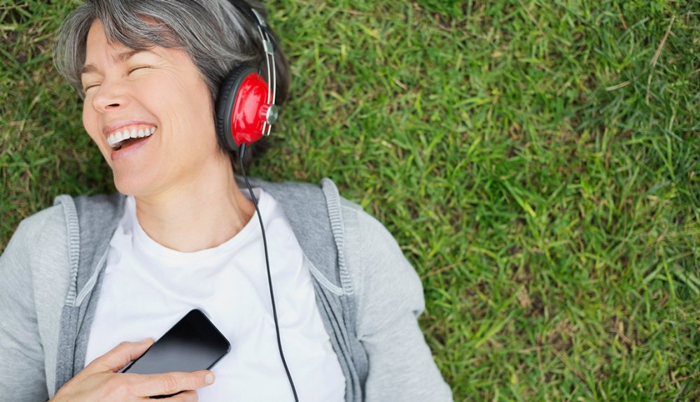 https://cdn.aarp.net/content/dam/aarp/research/surveys_statistics/technology/2019/1140-woman-listening-to-headphones.imgcache.rev.web.1000.575.jpg